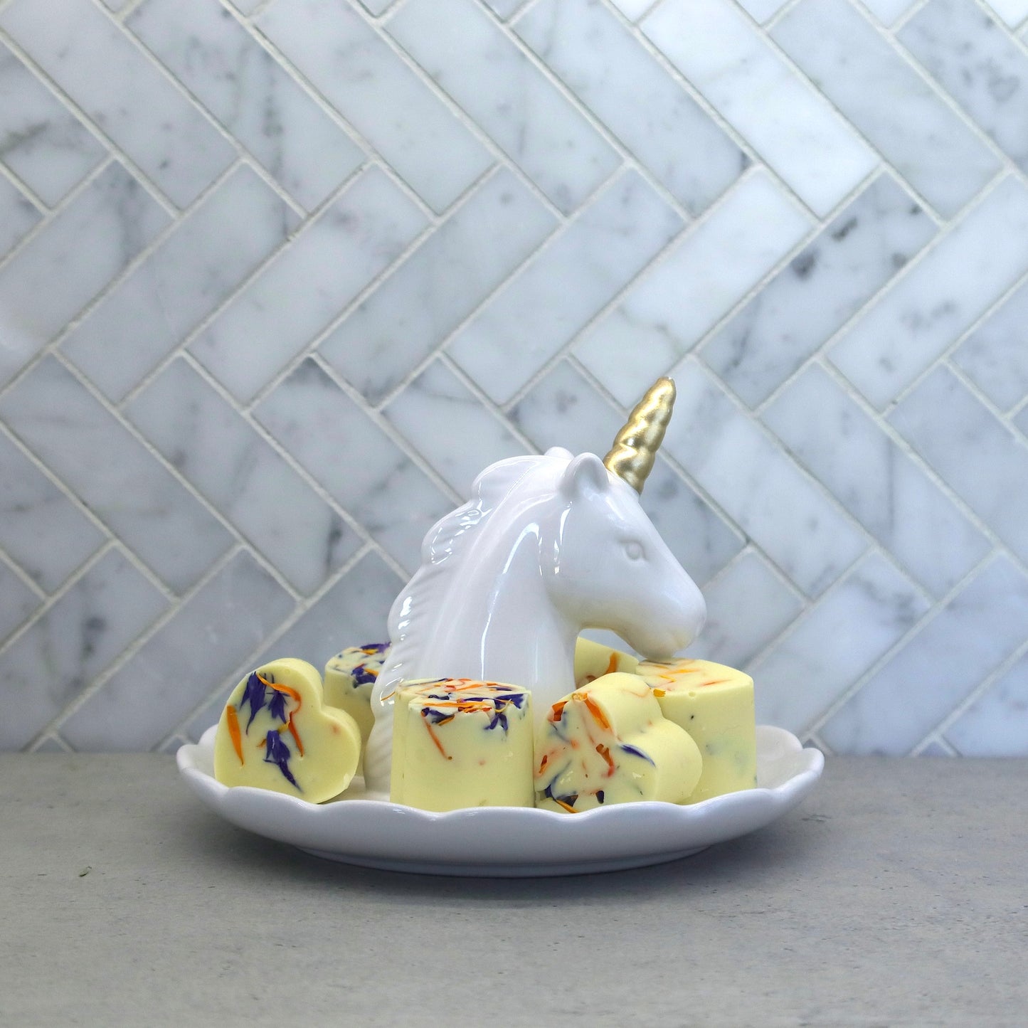 chocolates decorated with Native Tree Farm, edible flower petals sitting in a unicorn dish on a kitchen bench