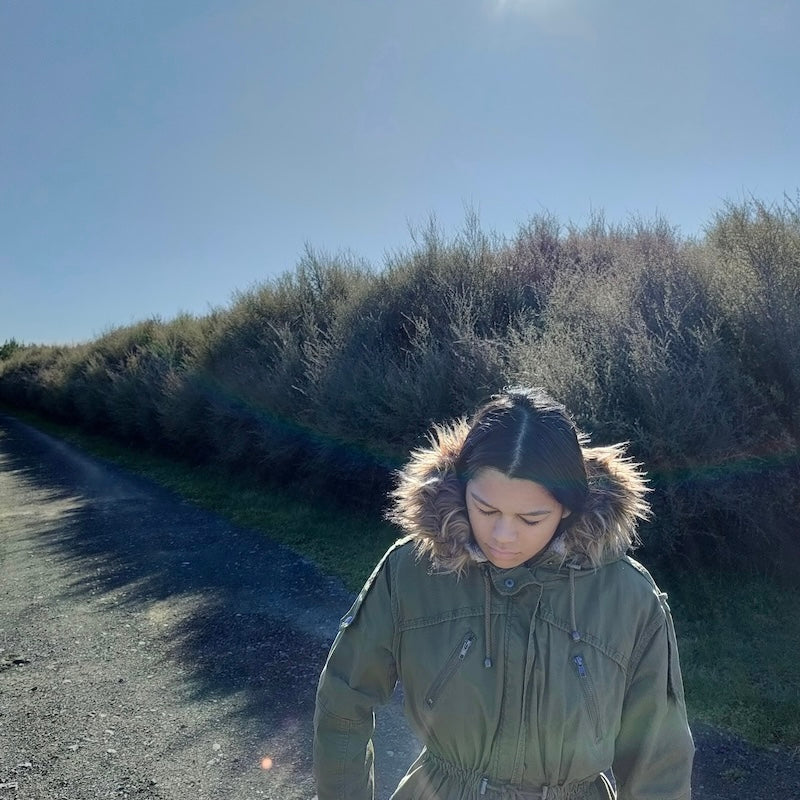 A local maori girl walking through organic manuka plantation in new zealand.