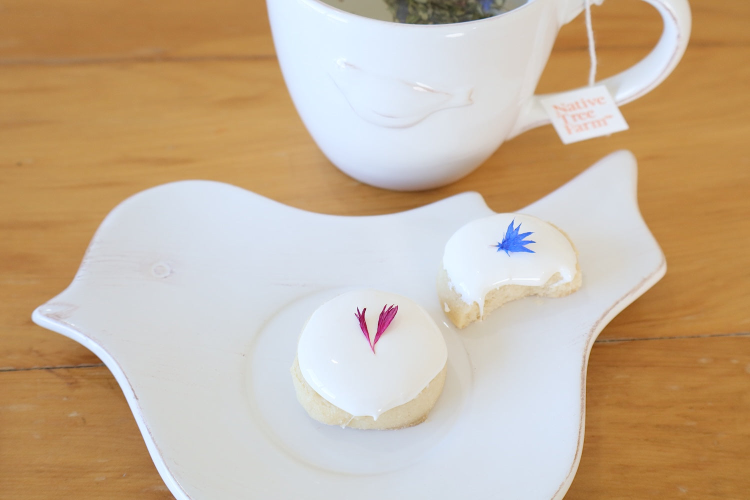two cookies decorated with Native Tree Farms edible flower petals