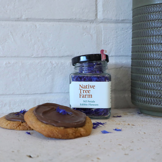 A glass jar of Native Tree Farm blue and purple edible flowers 