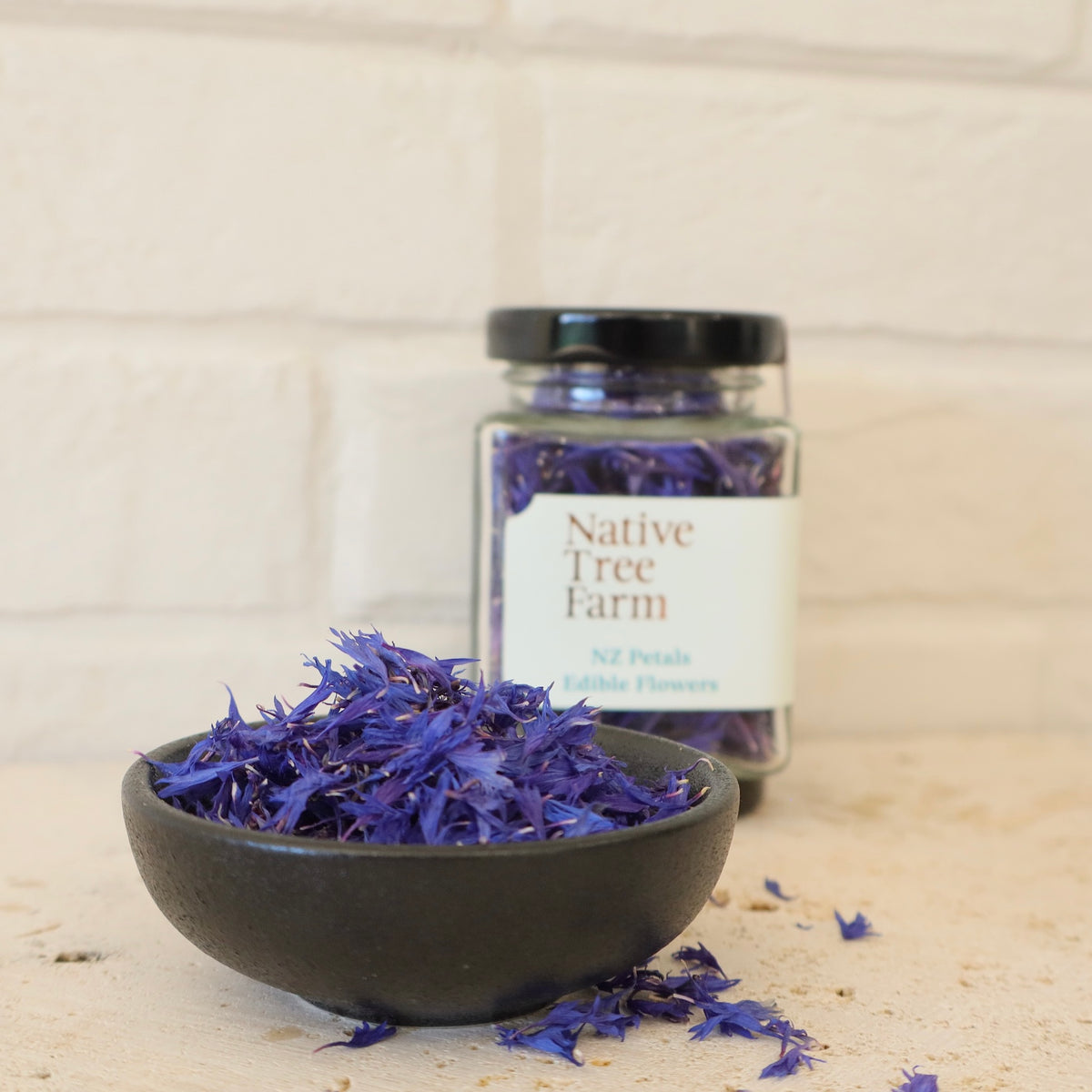 blue edible petals from Native Tree Farm next to a chocolate cookie
