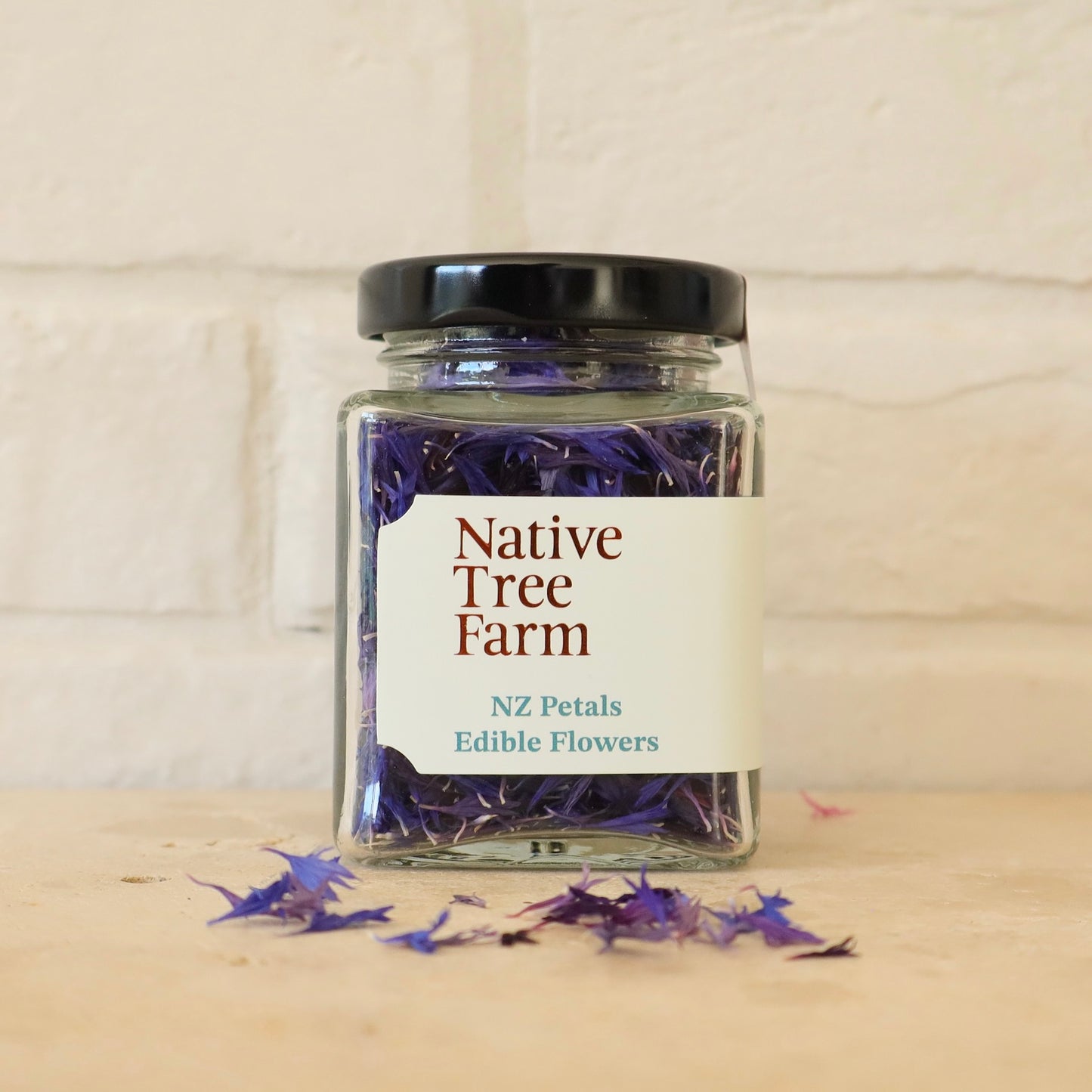 Jar of Native Tree Farm NZ Petals Edible Flowers on a wooden surface with a white background
