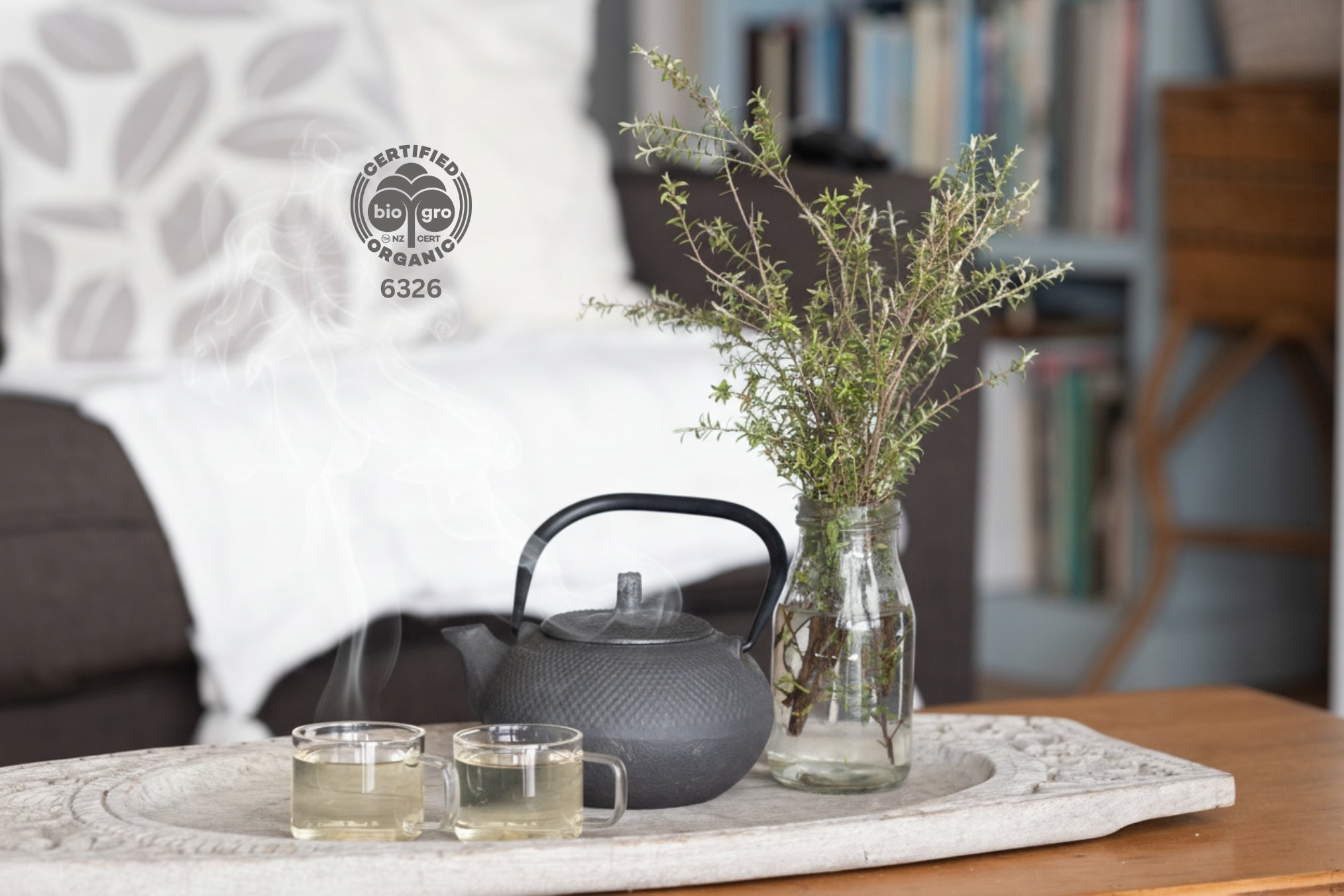 Tea set with a teapot and cups on a marble tray, featuring a Certified Organic logo. and manuka herbal tea 
