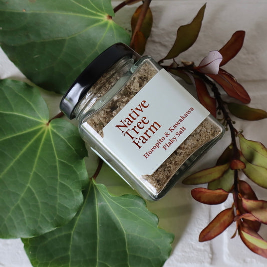 Jar of Native Tree Farm Horopito and Kawakawa flaky salt on a leafy background