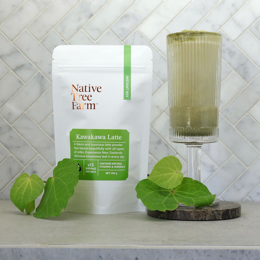 Native Tree Farm Kawakawa Latte package with green kawakawa leaves on a marble table.