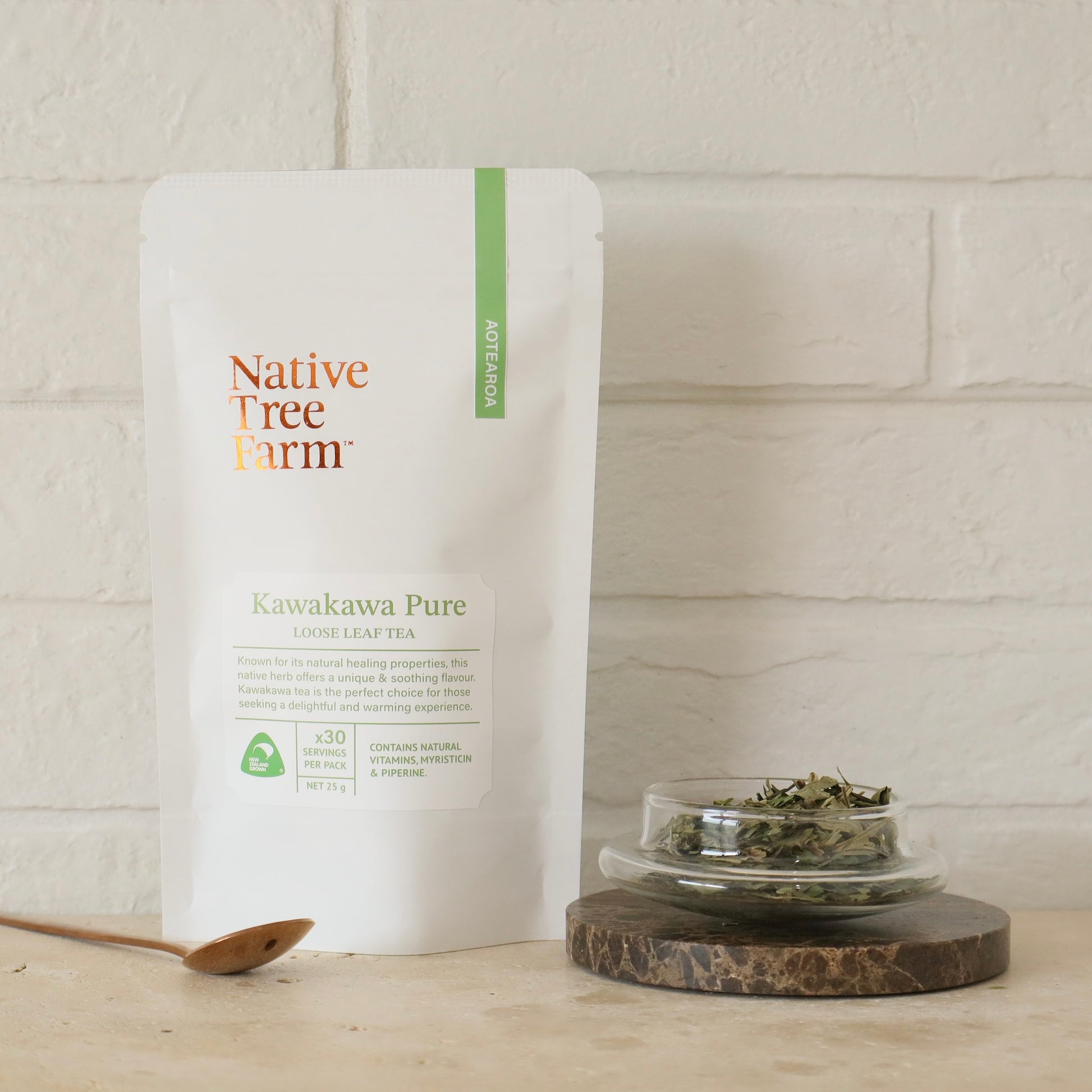 Native Tree Farm Kawakawa Pure tea packaging with a small dish of kawakawa tea leaves on a wooden surface.