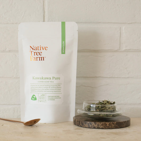 Native Tree Farm Kawakawa Pure tea packaging with a small dish of kawakawa tea leaves on a wooden surface.