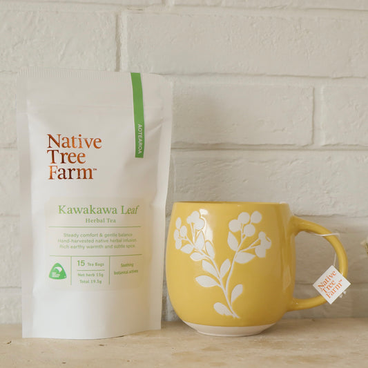 Native Tree Farm Kawakawa Leaf Herbal Tea package with a yellow mug on a wooden surface.