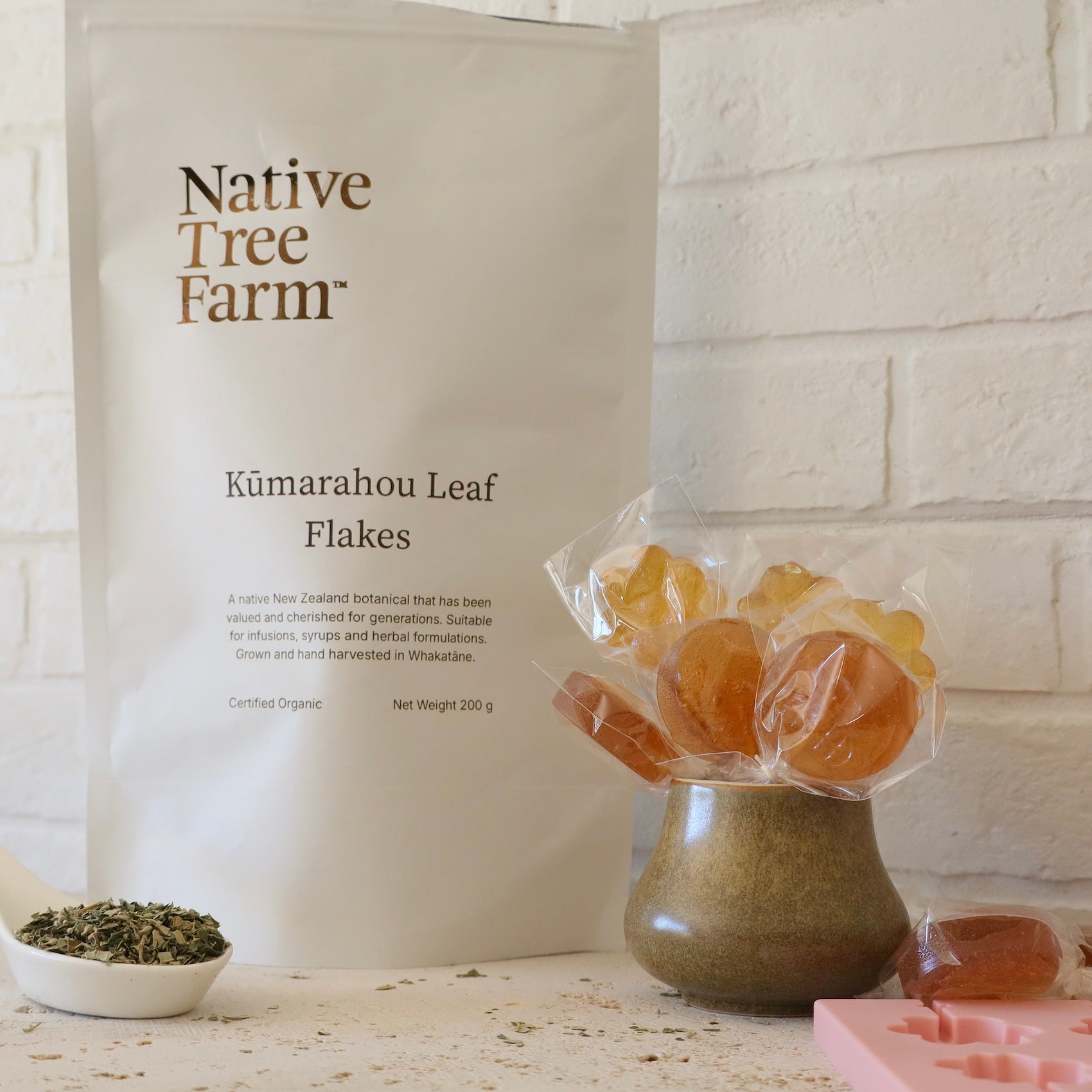 Native Tree Farm kūmarahou leaf flakes in a pouch on a stone bench