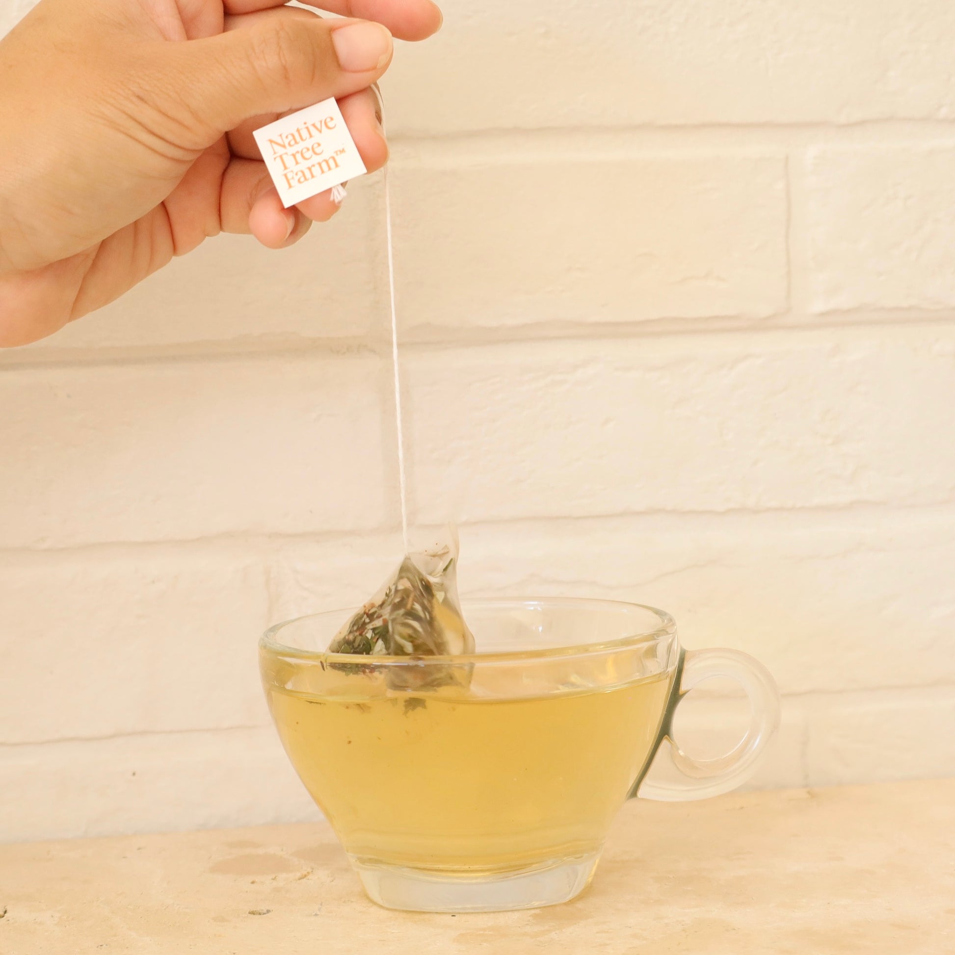 kumaahou Tea bag being added to a glass of tea 
