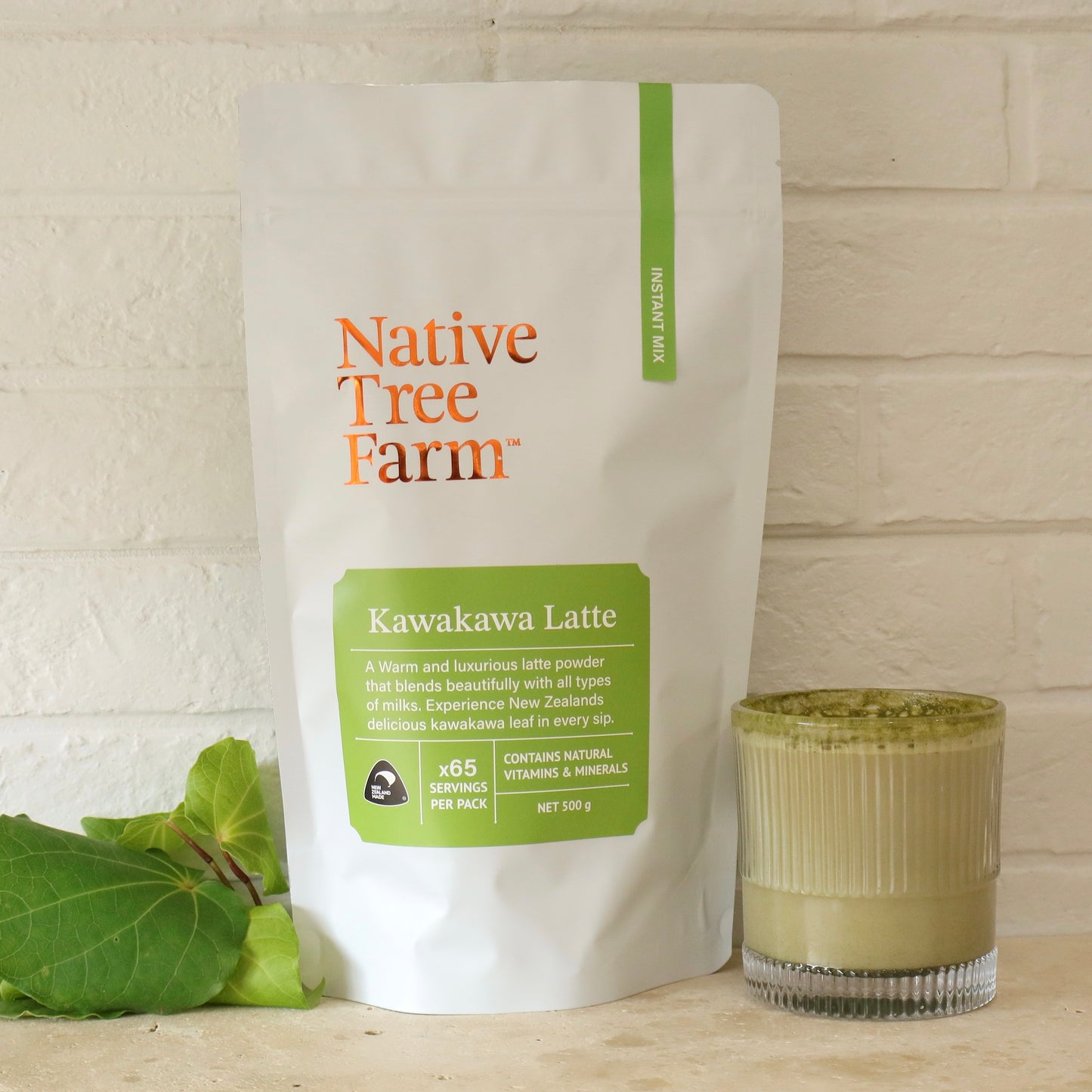 Native Tree Farm Kawakawa Latte package with a glass of latte on a wooden surface.