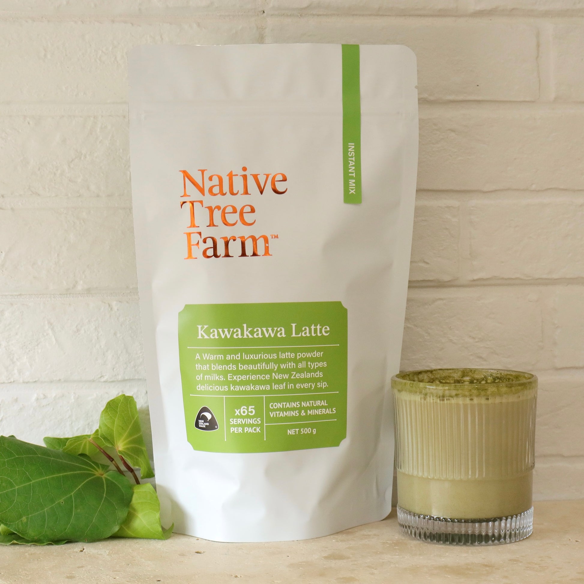 Native Tree Farm Kawakawa Latte package with a glass of latte on a wooden surface.