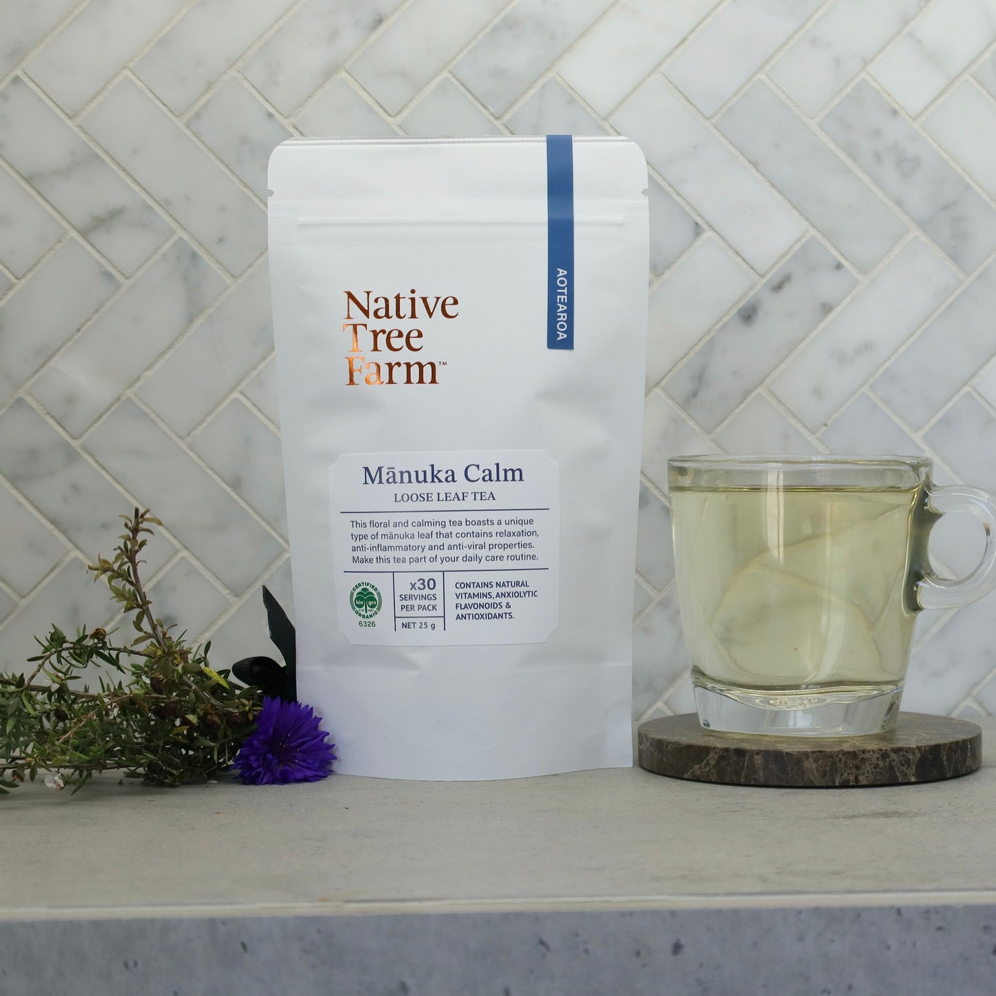Native Tree Farm Mánuka Calm tea package with a glass of tea on a kitchen bench