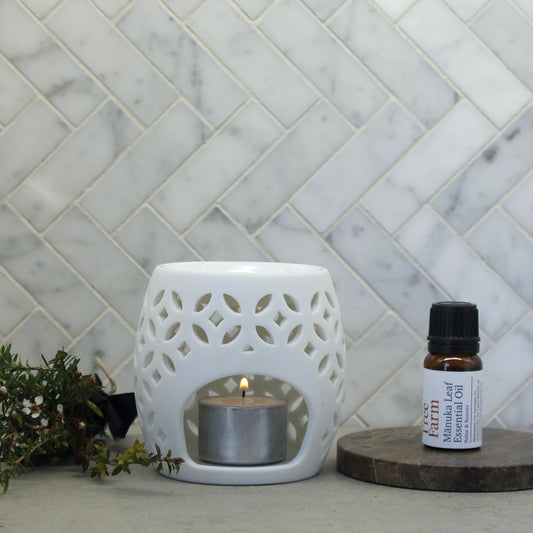 a bottle of Native Tree Farm's certified organic manuka essential oil on a marble table