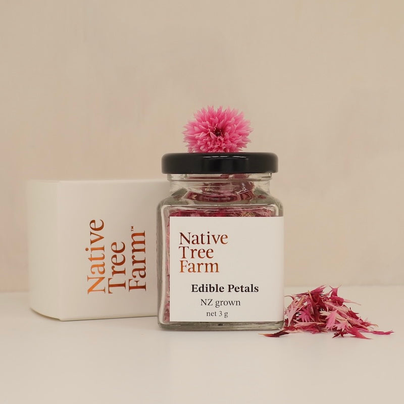 Pink edible flower petals in a square jar.